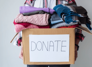 box piled with donations of used clothing