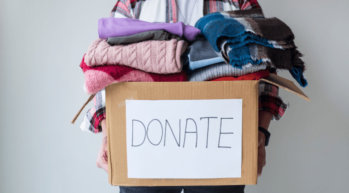 box piled with donations of used clothing