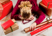 mom laying on top of holiday wrapping paper