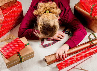 mom laying on top of holiday wrapping paper