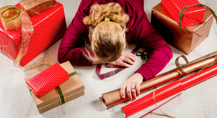 mom laying on top of holiday wrapping paper