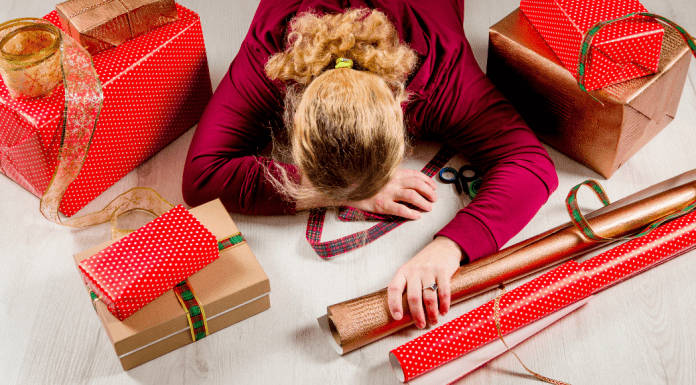 mom laying on top of holiday wrapping paper