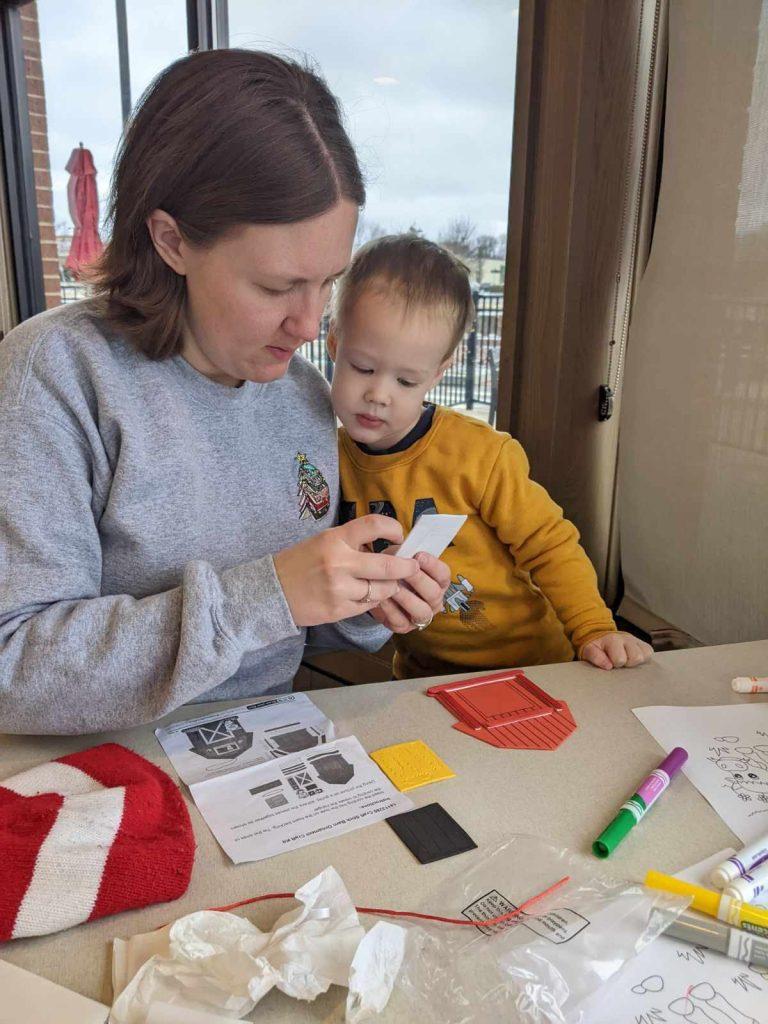 Mother and son complete a farm-themed craft at a Chick-fil-A table as part of storytime