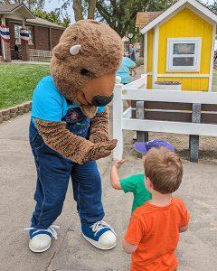 Two toddler boys high five Ike the American bison, a costumed performer