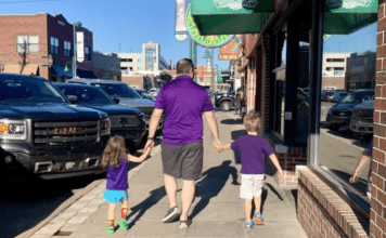 family walking on sidewalk in Aggieville, Manhattan, Kansas