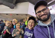 family smiling at K-State volleyball game