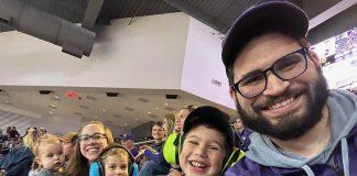 family smiling at K-State volleyball game