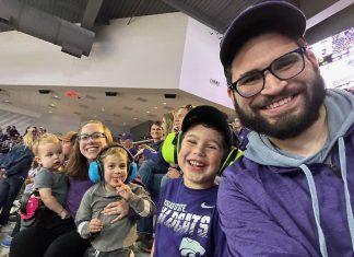 family smiling at K-State volleyball game