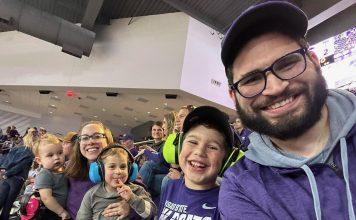 family smiling at K-State volleyball game